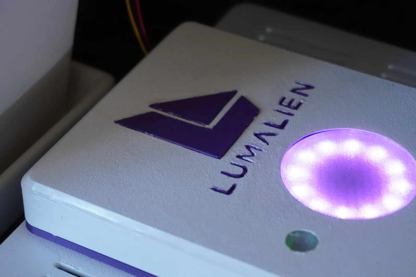 Close-up of the FLORA console: the purple Lumalien mark, the lit halo ring and the small light-sensor window